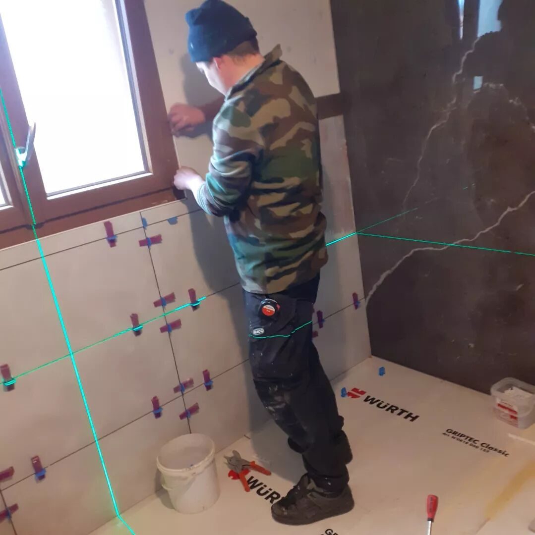 Pose de grands carreaux effet marbre au laser dans une salle de bains